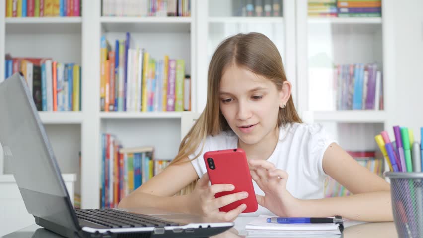 Kid Using Smartphone Studying in Video Conferencing, Child Learning, Writing in Library, Schoolgirl Chatting, Online Education Royalty-Free Stock Footage #1099237855