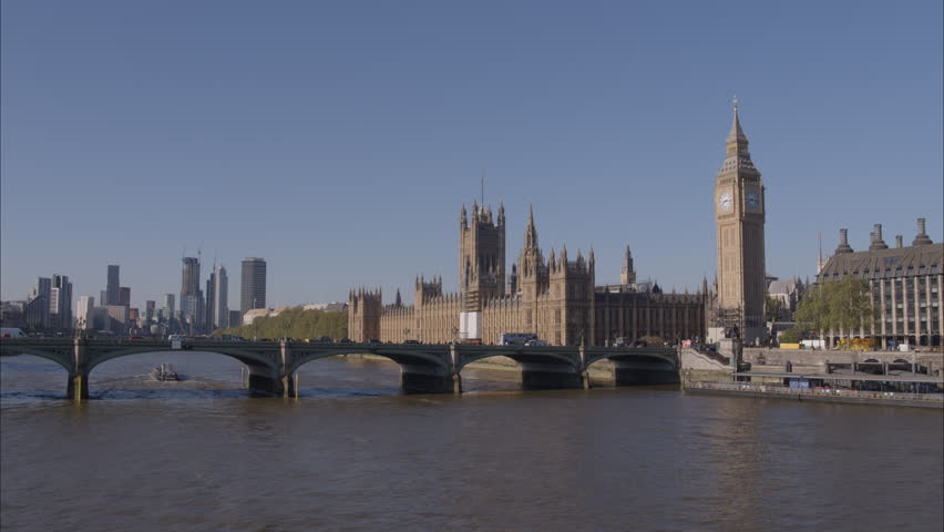 Aerial drone shot flying towards Westminster Bridge, Westminster Abbey and Big Ben over the River Thames with busy traffic crossing London Bridge on a bright clear sunny day. Royalty-Free Stock Footage #1099238775