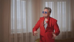 a man in a red jacket and blue glasses dances cool. High quality Full HD video recording