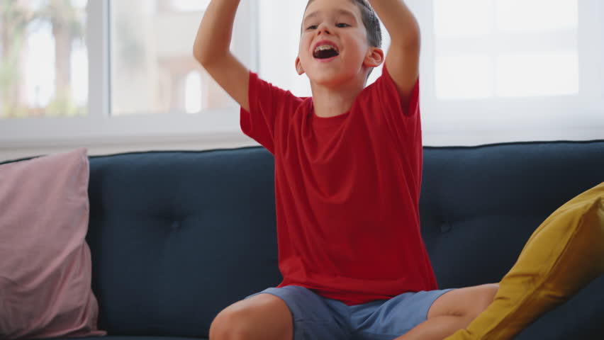 Schoolboy celebrating victory in a video game, leisure time for kids at home | Shutterstock HD Video #1099240435
