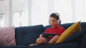 Little boy playing video games on tablet, children's lifestyle, gadgets