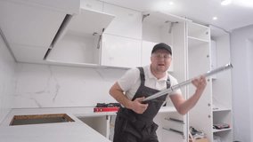A young man pretending to play the guitar while renovating using a vacuum cleaner.4k video