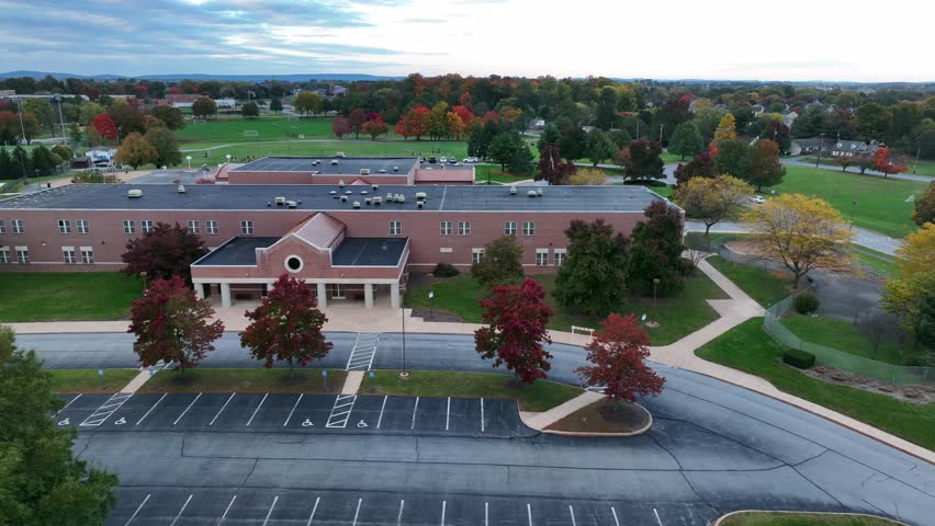 Aerial truck shot of small elementary school in autumn. Unrecognizable school building. Royalty-Free Stock Footage #1099245223