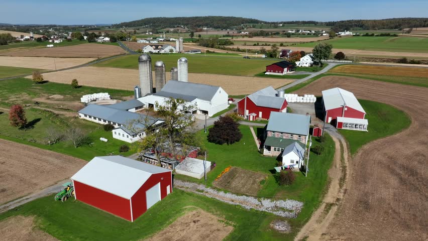 Red farm and barn buildings. American family farm in rural USA. Rolling hills of Lancaster County Pennsylvania.