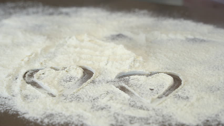 We draw a heart on flour with a baking dish | Shutterstock HD Video #1099249293