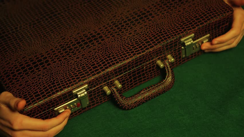 A man is seen unlocking a briefcase in a dimly lit nightclub. As he opens it, the camera reveals a stack of crisp 100-dollar notes filling the case, creating a sense of wealth and success. Royalty-Free Stock Footage #1099251015