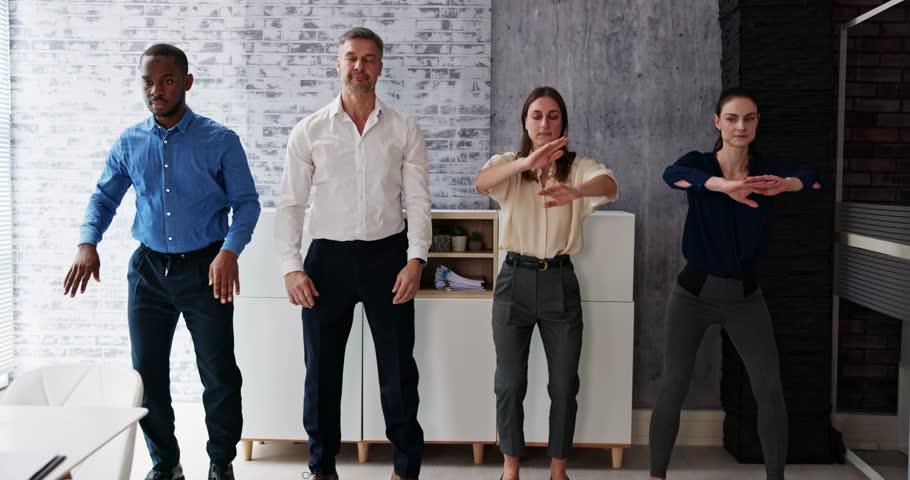 Group Of Happy Young Businesspeople Doing Stretching Exercise In Office | Shutterstock HD Video #1099251431