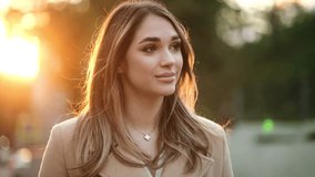 Close up view of charming woman looking to camera. Portrait of pretty girl standing at sunset light