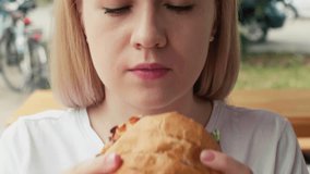 Close-up of a woman eating a beef burger. Enjoys food Pleasure. fast food. slow motion 4k video.