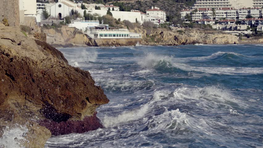 Big waves crash against the rocky shore