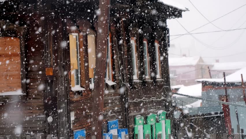old wooden house it is snowing heavily