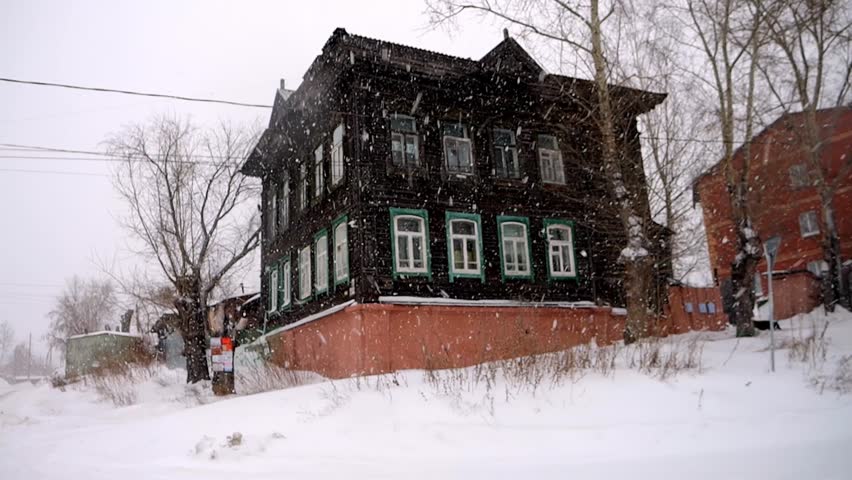 old wooden house it is snowing heavily