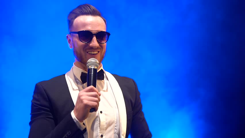 singer in a suit sings and dances on stage in the style of rap