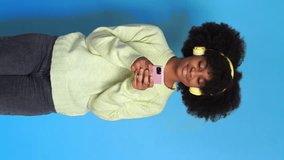 Cheerful black woman using smartphone. Vertical Video.