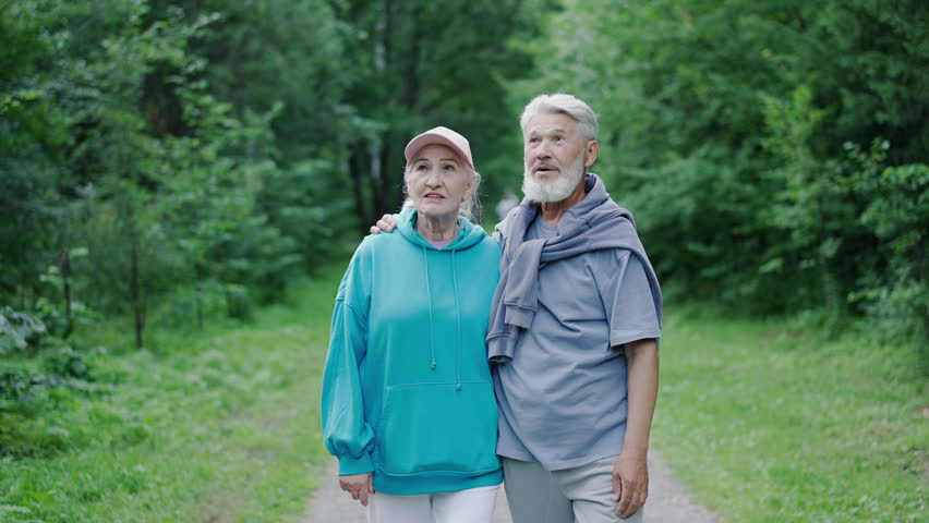 Couple old loving people walk nature forest park. Cute senior grandparents enjoy talk. Happy elder family stroll close up. Old pensioners pair date green wood. Elderly romantic husband person hug wife Royalty-Free Stock Footage #1099270999