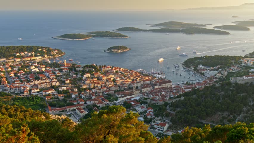 Aerial view of Hvar city, Croatia. Hvar island during sunset. Panoramic shot of the island city and Yachts sailing the Adriatic sea. UHD