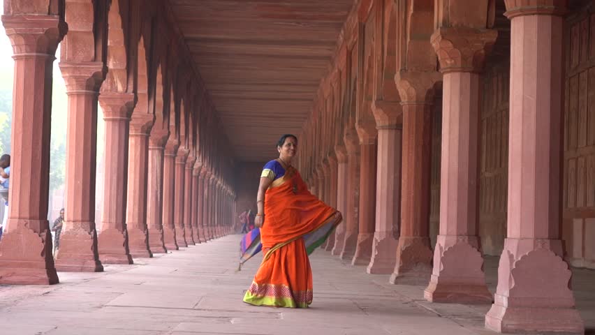 Woman tourist in front of Taj Mahal, UNESCO World Heritage site in Agra, India.