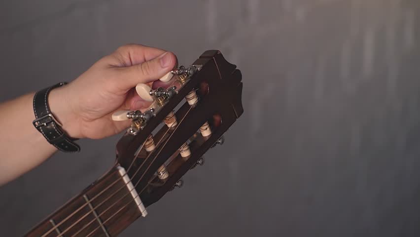 a man tunes an acoustic guitar. High quality Full HD video recording Royalty-Free Stock Footage #1099277307