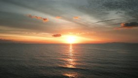 Aerial view of sunset horizon over the sea. Cinematic drone aerial view beautiful evening sunset in sky over sea. Sun path is reflected in sea surface. Nature beauty.