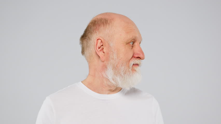 Old man with long grey beard is turning his head, looking at camera and smiling. | Shutterstock HD Video #1099284441