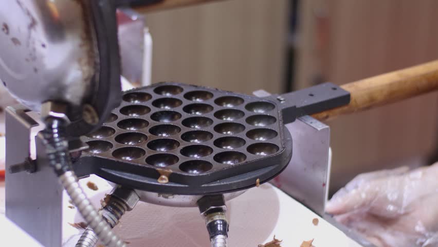 Selective focus to video of chocolate waffles being baked and sold at culinary festival at night, soft focus and with motion blur effect | Shutterstock HD Video #1099294737