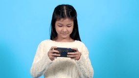 Asian cute school element girl lifestyle show talent play video game, adorable kid competition to online game in smartphone, happy kid focus on social media watching or searching education or game