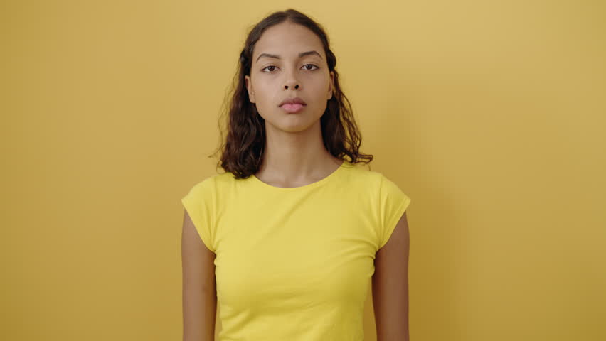 Young african american woman smiling confident doing photo gesture with hands over isolated yellow background | Shutterstock HD Video #1099297703