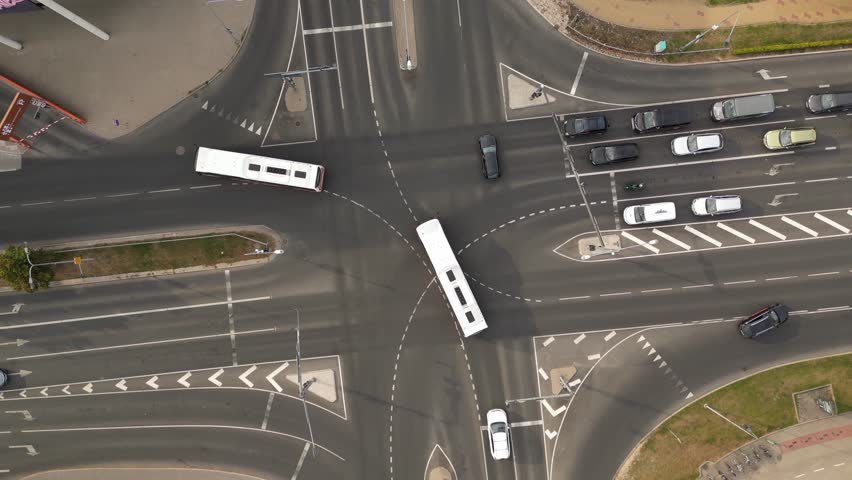 Top down aerial of cars drive at cross road. Heavy traffic in downtown streets. Pedestrians crossing busy intersection. Traffic highway transportation. Fast moving cars, trucks, buses and trains | Shutterstock HD Video #1099298357