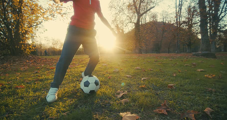 Child playing football, family fun outdoors players in Football in dynamic action have fun playing football in the grass, sunny day under sunlight. | Shutterstock HD Video #1099299663