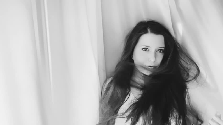 Beautiful young woman with long hairstyle, black and white slow motion portrait indoors, healthy hair and hair care concept