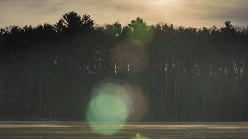 Time-lapse of sunrise through the trees on the far side of a small lake in northern Michigan. Shot in 4K