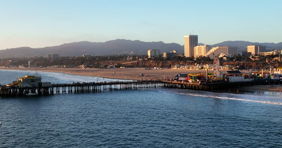 Aerial Shot Of Famous Pier At Beach In Residential City, Drone Flying Forward Over Sea - Santa Monica, California
