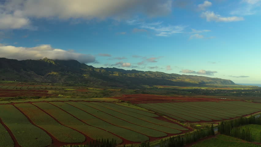 Aerial Backward Beautiful View Of Green Agricultural Landscape By Mountains Under Cloudy Sky - Oahu, Hawaii