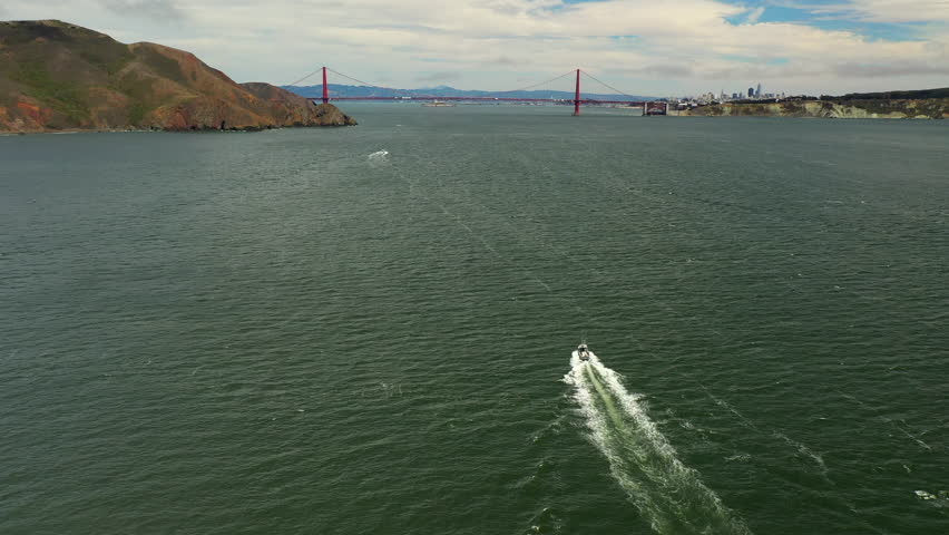 Aerial Downward Shot Of Ship Moving On Sea Towards Suspension Bridge Under Cloudy Sky - San Francisco, California