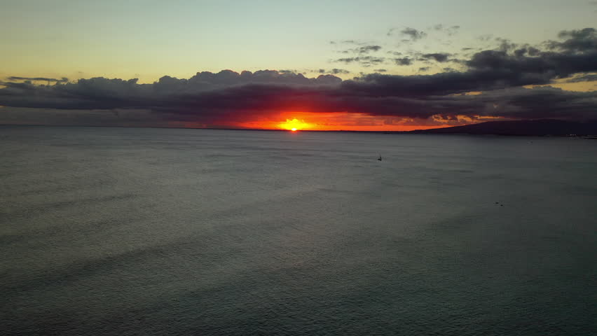 Aerial Shot Of Seascape With Silhouette Boat Against Sky, Drone Flying Backward Over Sea During Sunset - Oahu, Hawaii