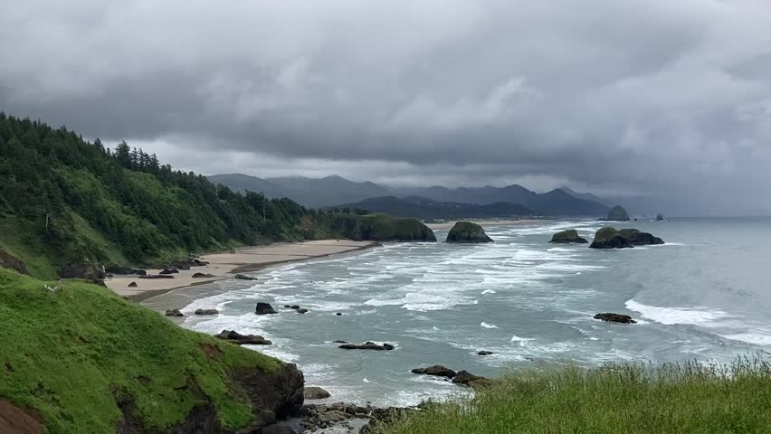 Beautiful elevated view over the coastline at Ecola State Park during dramatic Pacific Northwest weather. Clear view of Crescent Beach, rock stacks and ocean - Nr Cannon Beach, Oregon, USA Royalty-Free Stock Footage #1099313493