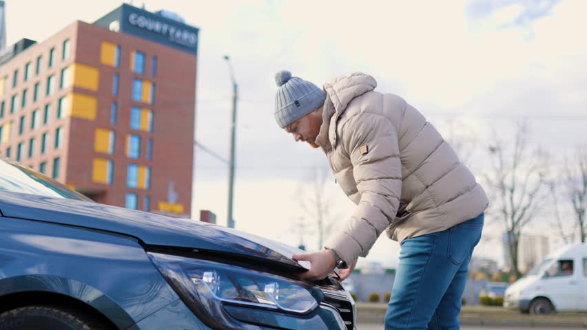 A man open the hood is seen working on a broken car, | Shutterstock HD Video #1099317665