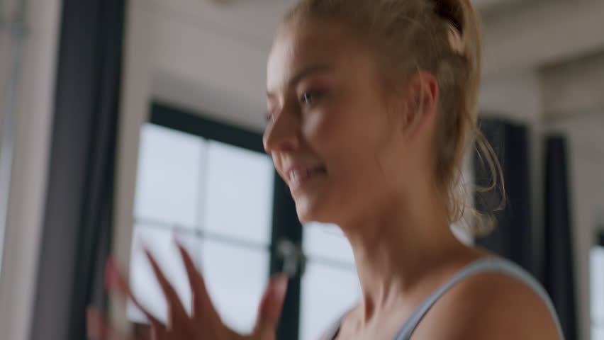 A young beautiful caucasian woman runs in place in the fitness studio - a close-up headshot | Shutterstock HD Video #1099319831