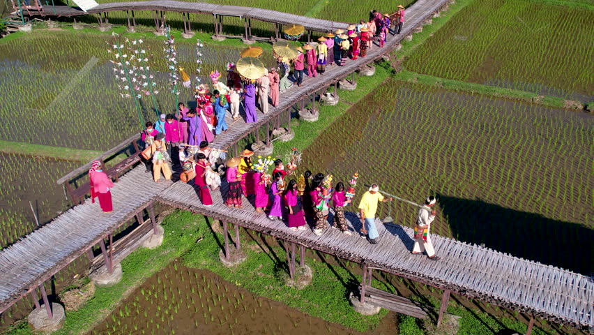 Aerial view fly over row of group of people join in ceremony or celebration in Poy Sang Long festival that part of cultural activities in Northern part of Thailand. Royalty-Free Stock Footage #1099320585