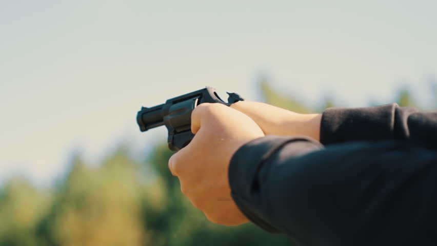 Hands of a man shooting a pistol with a revolving cylinder. High quality 4k footage