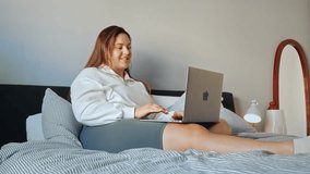 Positive overweight woman talking with her friend at the laptop camera