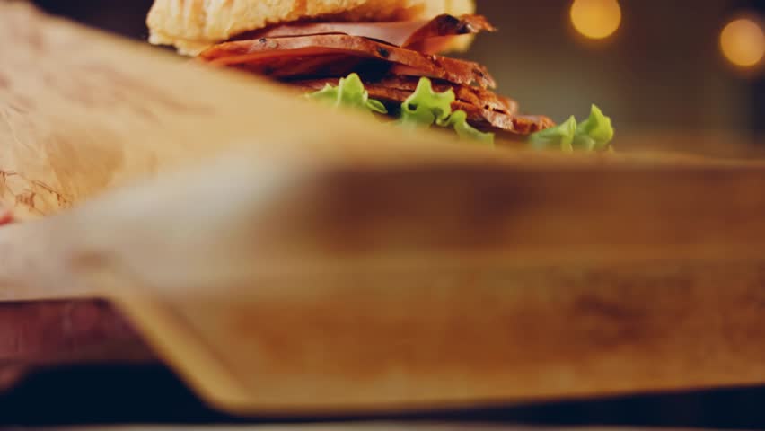 Waviness effect of Sandwich with French baguette, cheese, lettuce and sausage. Slider shooting. In the background is a retro baking tray and cooking paper | Shutterstock HD Video #1099323759
