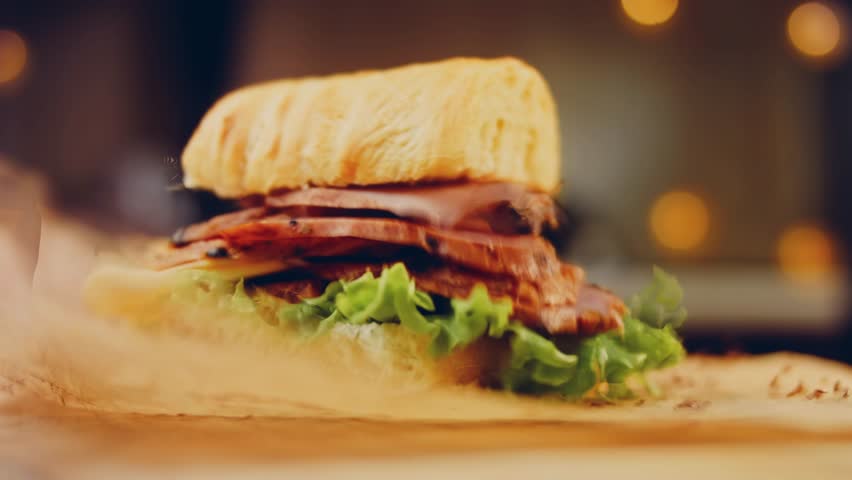 Waviness effect of Sandwich with French baguette, cheese, lettuce and sausage. Slider shooting. In the background is a retro baking tray and cooking paper | Shutterstock HD Video #1099323775