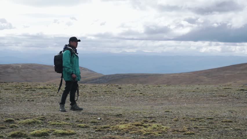 Young tourist taking pictures in the mountains of Peru in South America. Vacation, photography and tourism concept.