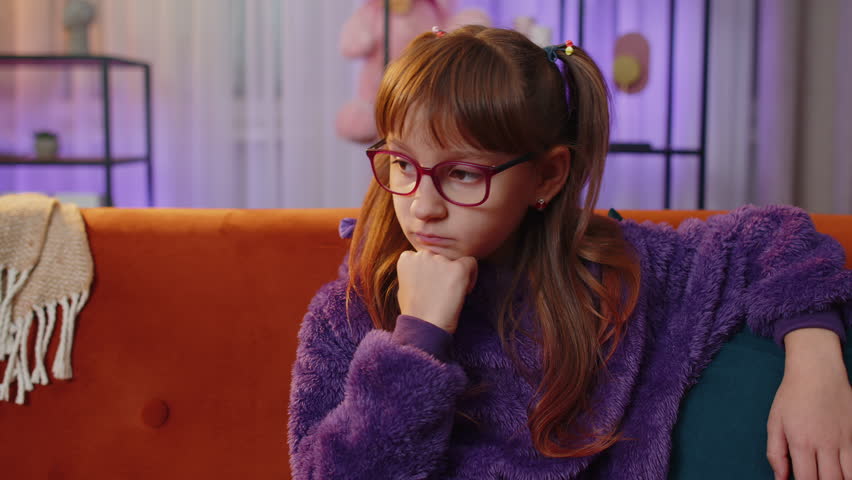 Sad lonely toddler girl at home looks pensive thinks over life concerns or unrequited love, suffers from unfair situation. Teen child, kid problem, break up, depressed feeling bad annoyed burnout | Shutterstock HD Video #1099330341