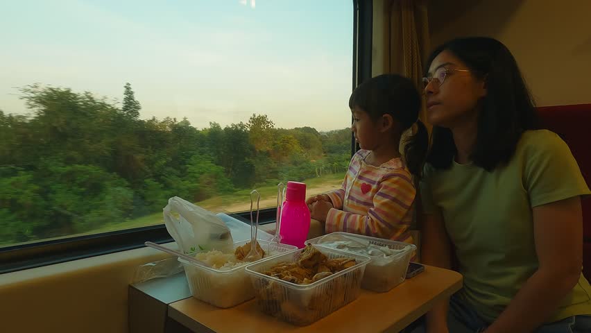 mother and daughter look out of the train window