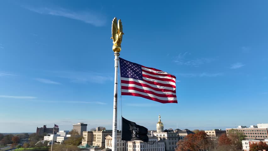 USA and POW MIA flags in Trenton New Jersey. State House capitol dome in distance. Aerial view.