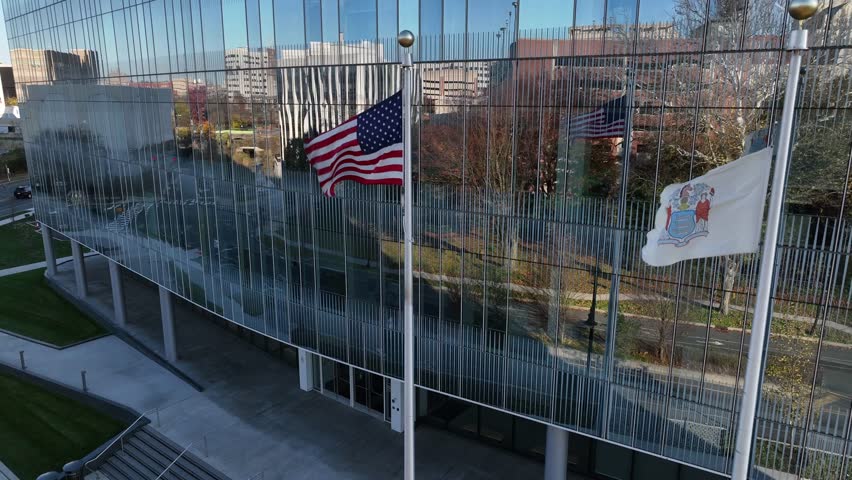 USA and State of New Jersey flags. NJ office building in downtown city. Royalty-Free Stock Footage #1099339021
