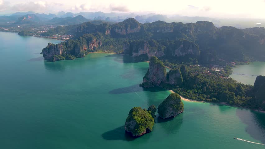 Aerial drone view of the limestone cliffs and tropical beach of Railay Beach Krabi Thailand at sunrise  Royalty-Free Stock Footage #1099340755