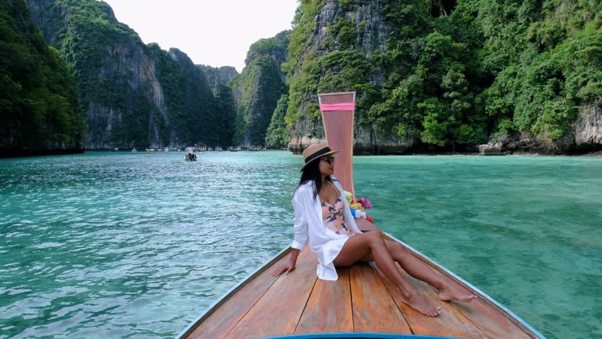 Asian women in front of a longtail boat at Koh Phi Phi Island Thailand, | Shutterstock HD Video #1099340851
